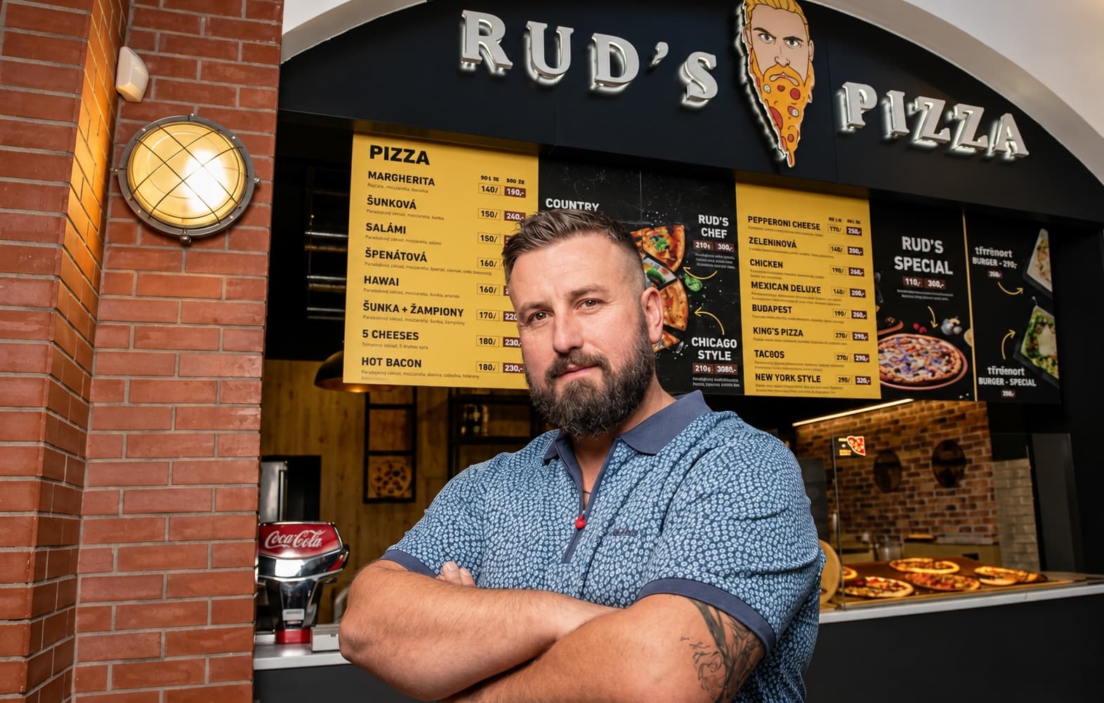Zakladatel Rudi Kolndrekaj ve své pizzerii, AI upravená fotografie